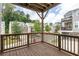 Wooden railed balcony overlooking tree-lined street and neighboring homes on a sunny day at 1995 Bryant Park Ln, Decatur, GA 30033