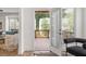 Open door shows balcony with wooded view just off the light-filled living room with hardwood floors at 1995 Bryant Park Ln, Decatur, GA 30033