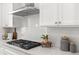 Bright kitchen featuring white cabinets, stainless steel hood, subway tile backsplash, and modern countertops at 1995 Bryant Park Ln, Decatur, GA 30033