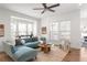 Bright living room featuring a stylish sectional sofa, modern decor, large windows, and hardwood floors at 1995 Bryant Park Ln, Decatur, GA 30033