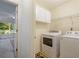 Convenient laundry room with washer, dryer, and storage cabinets, next to a porch at 2206 Heritage Trace Dr, Marietta, GA 30062
