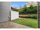 Green backyard with patio, white fence, and lush landscaping with a retaining wall at 2731 Pierce Brennen Ct, Lawrenceville, GA 30043