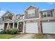 Charming townhome with stone accents, covered entrance, and an attached garage on a sunny day at 2731 Pierce Brennen Ct, Lawrenceville, GA 30043