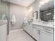 Stylish bathroom with double sinks, white cabinets, quartz countertops, and a tiled shower at 671 Brennan Dr, Decatur, GA 30033