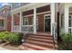 Charming front entry with brick steps, a black front door, and a covered porch at 671 Brennan Dr, Decatur, GA 30033