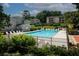Community pool surrounded by trees, lounge chairs and well maintained landscaping at 1150 Collier Rd # K3, Atlanta, GA 30318