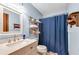 Cozy bathroom featuring a sink, toilet, and shower with blue shower curtain at 3754 Wyntuck Nw Cir, Kennesaw, GA 30152