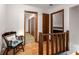 Upstairs hallway with hardwood floors, chair with pillow, and multiple doorways at 3754 Wyntuck Nw Cir, Kennesaw, GA 30152