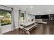 Bright dining room with large windows, hardwood floors, and a modern farmhouse-style table at 3844 Sw Saddle Ridge Dr, Snellville, GA 30039