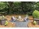 Backyard firepit area surrounded by mature trees, landscaping and comfortable seating at 3844 Sw Saddle Ridge Dr, Snellville, GA 30039