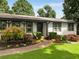 Close-up of the front entrance, showcasing the manicured lawn, vibrant flower beds, and a curved walkway at 3844 Sw Saddle Ridge Dr, Snellville, GA 30039