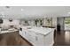 Open kitchen and living area with a large island, dark wood floors, and lots of light at 3844 Sw Saddle Ridge Dr, Snellville, GA 30039