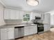 Updated kitchen featuring stainless steel appliances, white cabinets, and granite countertops for a modern design at 5159 Round Table Dr, Ellenwood, GA 30294