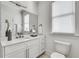 Modern bathroom featuring a white vanity with a quartz counter, decorative mirror and a toilet at 658 Mcgruder Ne St, Atlanta, GA 30312
