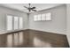 Light-filled bedroom with hardwood floors, ceiling fan, and double doors to balcony at 658 Mcgruder Ne St, Atlanta, GA 30312