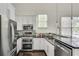 Modern kitchen with stainless steel appliances, white cabinets, and sleek backsplash at 658 Mcgruder Ne St, Atlanta, GA 30312