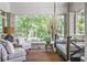 Relaxing screened porch with swing, seating area, brick walls, and views of the trees at 15 Northwood Ne Ave, Atlanta, GA 30309