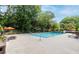 Bright swimming pool featuring lounge chairs and seating areas under orange umbrellas near lush greenery at 1501 Clairmont Rd # 1522, Decatur, GA 30033