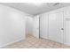A finished basement area with tile flooring, white walls and ceilings, and access to storage or utility areas at 165 Lost Lake Trl, Villa Rica, GA 30180