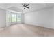 Bright bedroom with ceiling fan, large windows, and neutral carpeted flooring at 165 Lost Lake Trl, Villa Rica, GA 30180