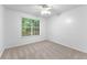 Bright, carpeted bedroom with a large window providing natural light and views of the greenery outside at 165 Lost Lake Trl, Villa Rica, GA 30180