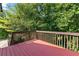 A wood deck featuring stained wood flooring and railing with a view of the surrounding trees at 165 Lost Lake Trl, Villa Rica, GA 30180