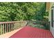 Wood deck featuring stained wood flooring and railing with a view of the surrounding trees at 165 Lost Lake Trl, Villa Rica, GA 30180
