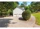 Exterior shot of a house showcasing a two-car garage and driveway, surrounded by mature trees at 165 Lost Lake Trl, Villa Rica, GA 30180