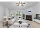 Staged living room featuring a fireplace, neutral carpet, ceiling fan and bright window at 165 Lost Lake Trl, Villa Rica, GA 30180