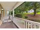 View of a covered porch featuring stone accents, wooden flooring, and a view of the front yard at 165 Lost Lake Trl, Villa Rica, GA 30180