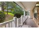 Inviting covered porch with stone accents, a wooden deck, and a view of the front yard and surrounding trees at 165 Lost Lake Trl, Villa Rica, GA 30180