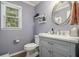 Bathroom vanity with marble countertop, oval mirror and decoratively adorned shelves at 4271 Keheley Ne Rd, Marietta, GA 30066