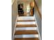 Staircase with wood treads and white risers leading to kitchen area at 120 Alfred Dr, Carrollton, GA 30116