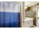 Well-lit bathroom featuring blue and white shower curtain, and a vanity with an undermount sink at 168 Gatlin Ridge Run, Dallas, GA 30157