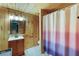 Bathroom features wood walls, tiled floors, vanity, mirror, and shower with blue-pink gradient shower curtain at 168 Gatlin Ridge Run, Dallas, GA 30157