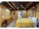 Bedroom has a wooden ceiling and walls, ceiling fan, dresser, queen bed with yellow floral bedding at 168 Gatlin Ridge Run, Dallas, GA 30157