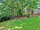 Green backyard featuring a treehouse in a wooded area, grassy lawn and healthy shrubbery at 1808 Jacksons Creek Dr, Marietta, GA 30068