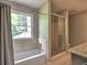 Serene bathroom with tub, shower, and window, offering a relaxing space with modern fixtures at 1808 Jacksons Creek Dr, Marietta, GA 30068