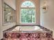 Bright bathroom showcasing a soaking tub with marble platform and an arched window overlooking the greenery at 1808 Jacksons Creek Dr, Marietta, GA 30068