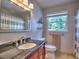 Bright bathroom featuring granite counters, stylish fixtures, and a large mirror reflecting a charming striped shower curtain at 1808 Jacksons Creek Dr, Marietta, GA 30068