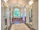 Elegant bathroom featuring marble floors, a chandelier, and a large arched window over the bathtub at 1808 Jacksons Creek Dr, Marietta, GA 30068
