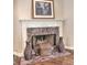 The fireplace has a marble surround with wooden accents and is flanked by tall vases at 1808 Jacksons Creek Dr, Marietta, GA 30068
