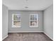 Bedroom showcasing gray walls, carpeting, and two windows overlooking the front yard at 2165 Capella Cir, South Fulton, GA 30331