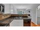Updated kitchen with double sink, wood floors, granite counters, and view of living room at 2165 Capella Cir, South Fulton, GA 30331