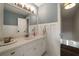 A bathroom vanity featuring white cabinets, marble countertops, and a large mirror at 4188 Kindlewood Ne Ct, Roswell, GA 30075