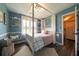A charming bedroom features blue walls, wood floors, and a luxurious canopy bed at 4188 Kindlewood Ne Ct, Roswell, GA 30075