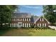Charming two-story brick home with a manicured lawn and a lovely light blue front door at 4188 Kindlewood Ne Ct, Roswell, GA 30075