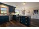 Bright kitchen with dark blue cabinets, stainless steel appliances, hardwood floors, and breakfast table at 4188 Kindlewood Ne Ct, Roswell, GA 30075