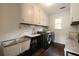 Convenient laundry room featuring modern washer and dryer, storage cabinets and sleek sink at 4188 Kindlewood Ne Ct, Roswell, GA 30075