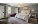 Comfortable primary bedroom with a decorative rug, large windows and accent lighting at 4188 Kindlewood Ne Ct, Roswell, GA 30075